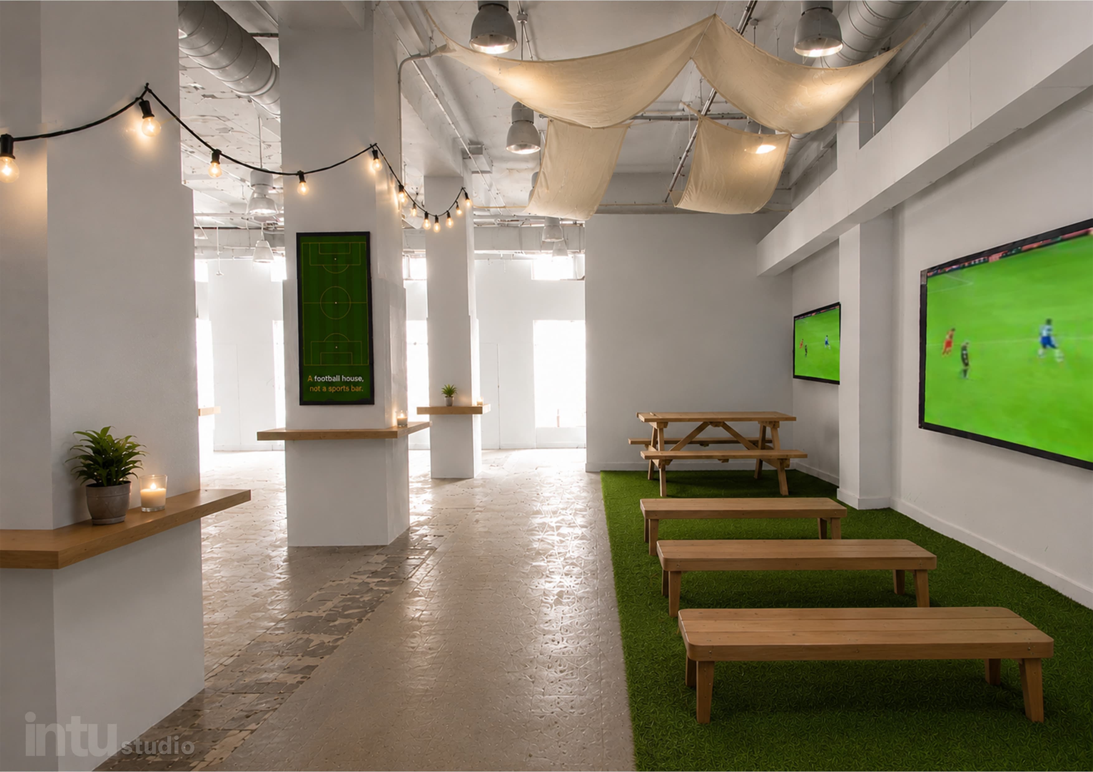 Bench seating area with turf flooring, candles, and big-screen match viewing